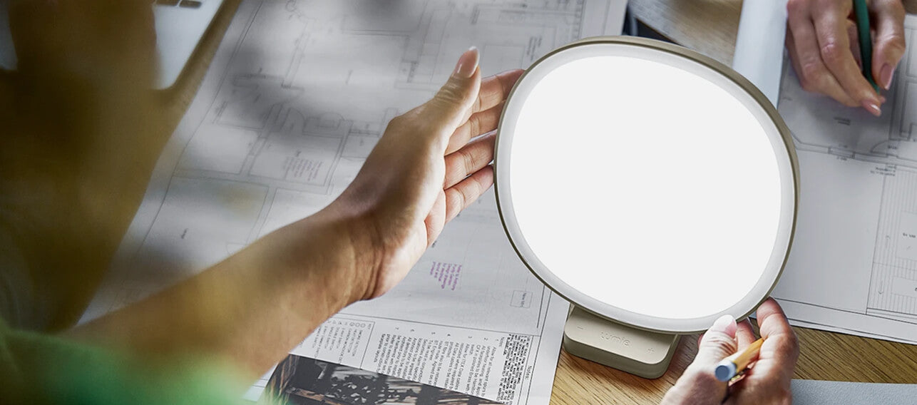 Person holding a round light source over a newspaper