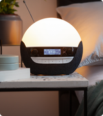 Round night light with digital display on a bedside table